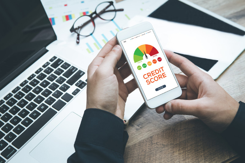 Phone with A Credit Score Meter On It With Laptop & Business Documents on Table | Credit Score